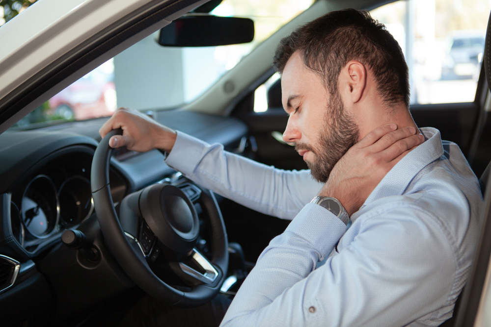Male-driver-having-neck-pain-sitting-in-his-car