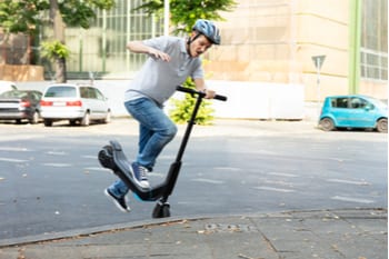 Man Having Accident Falling From E-Scooter On Street