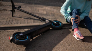 A Caucasian woman fell from an electric scooter and injured her leg. Suffering from pain