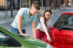 Young Woman Showing Man Car Collision At Roadside