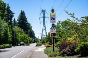Traffic safety in a residential and school zone, electronic sign that displays your speed, speeding cars on road in 20 MPH school zone